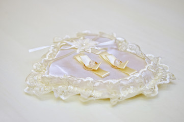 Two wedding gold rings on a cushion