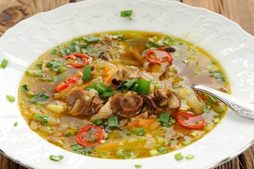 Wild mushroom and vegetable soup with chili in white plate