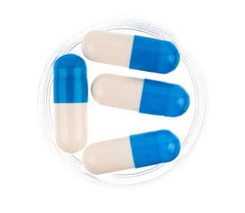 Close up of blue medical capsules on white background