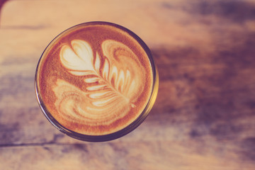 Latte art, Blue coffee cup on wooden background with vintage col