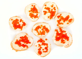 Red caviar on bread with butter on white plate closeup
