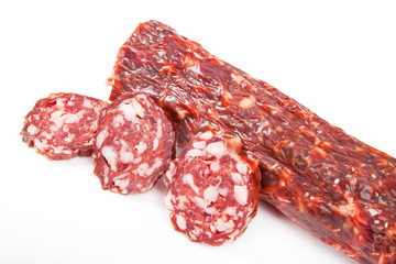 Slices italian salami sausage on white background