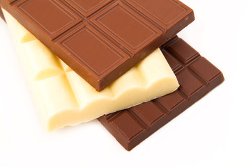 different sorts of chocolate in a stack on white background