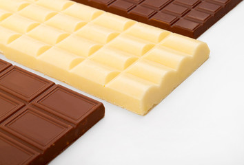 different sorts of chocolate in a stack on white background