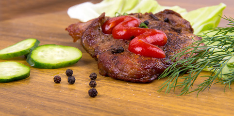 tasty grill meat with sauce and green on wooden background