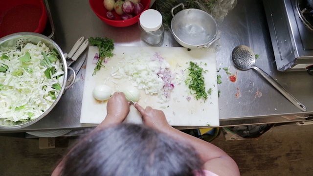 woman cutting onion in kitchen, view from top 