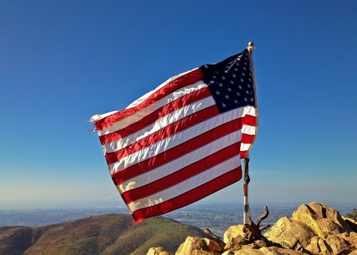 Tattered American Flag Blowing in the Wind Mountain Landscape