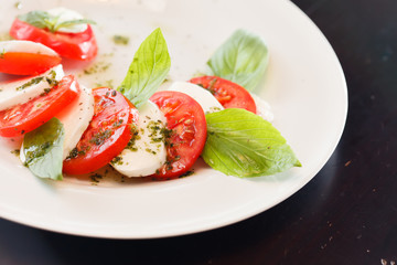 Tomato and mozzarella with basil leaves