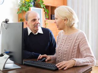 Senior couple using PC at home