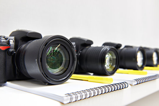Reflex digital cameras dslr with notepad close-up