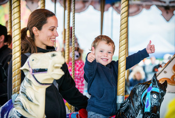 Boy with Two Thumbs Up with Mother on Carousel - 78136990