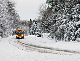 School Bus Driving Down A Snow Covered Rural Road - 1 - 78137317