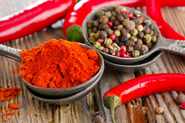 Black  and red  peppers on a wooden table.