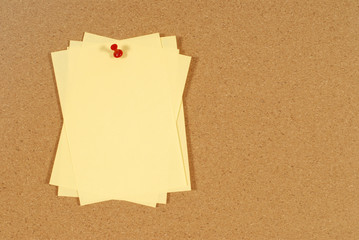 Cluster of yellow post it sticky notes pinned to a cork notice or bulletin board photo