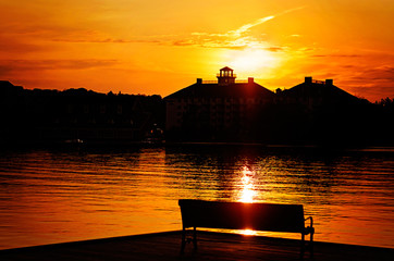 Naklejka na ściany i meble Silhouetted Park Bench By the Lake at Sunset
