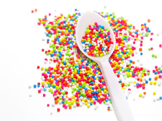 colorful sugar pearls in white spoon