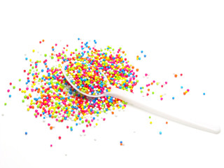 colorful sugar pearls in white spoon