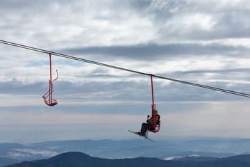 Skiers on chairlift in moutain