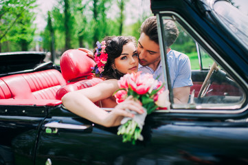 Young couple in vintage cars