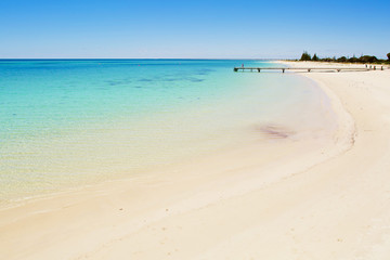 Pier in blue water of the ocean shore
