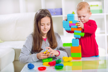 Obraz na płótnie Canvas Two children play with blocks