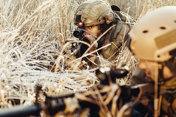 two soldiers in an ambush aim at the enemy