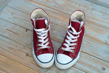 red canvas sneakers on a old wooden background