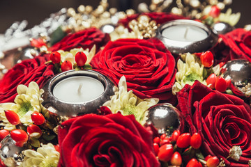 Red roses arrangement bouquet with candle for christmas