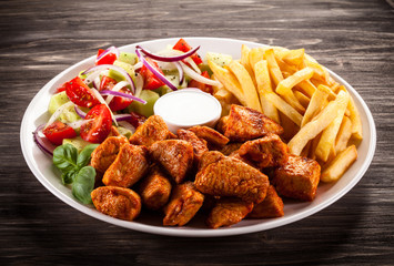 Fried chicken nuggets, French fries and vegetables