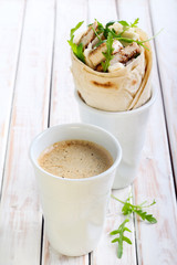 Mug of coffee and wrap roll