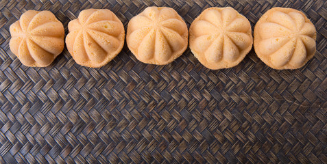 Kuih bahulu, a Malay sweet egg sponge cake on wicker mat.