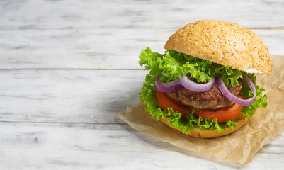 Burger with beef cutlet, lettuce, onions and tomato