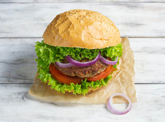 Burger with beef cutlet, lettuce, onions and tomato