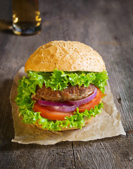 Burger with beef cutlet, lettuce, onions and tomato