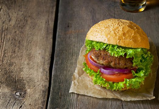 Burger with beef cutlet, lettuce, onions and tomato