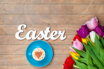 Cappuccino  and word Easter near flowers