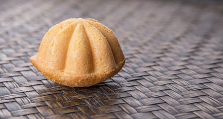 Kuih bahulu, a Malay sweet egg sponge cake on wicker mat.