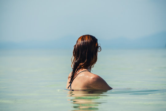 Woman sitting in water by beach