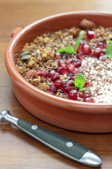 Bowl of granola with pomegranate seeds and yogurt.