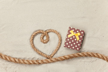 Fototapeta na wymiar Gift box and rope in heart shape