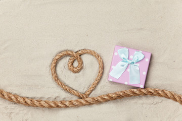 Fototapeta na wymiar Gift box and rope in heart shape
