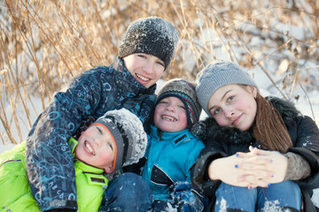 Happy children in winterwear laughing while playing in snowdrift