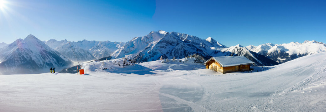 Winterpanorama mit Schifahrern und Schih&uuml;tte