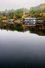 Old Wooden Boat House on a Calm Lake in the Fall - 78160775