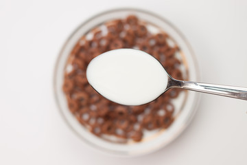 spoon full of milk in hand close-up breakfast concept