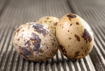 Obraz premium Quail eggs on wooden background closeup.