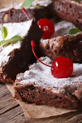 chocolate brownie cake with cherry closeup on paper. Vertical