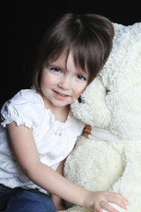 a little girl with bear on a black background