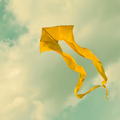 Yellow kite flying in the cloudy sky. Retro style © besjunior