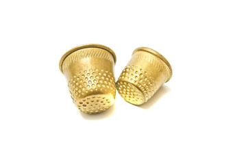 two golden thimbles on white